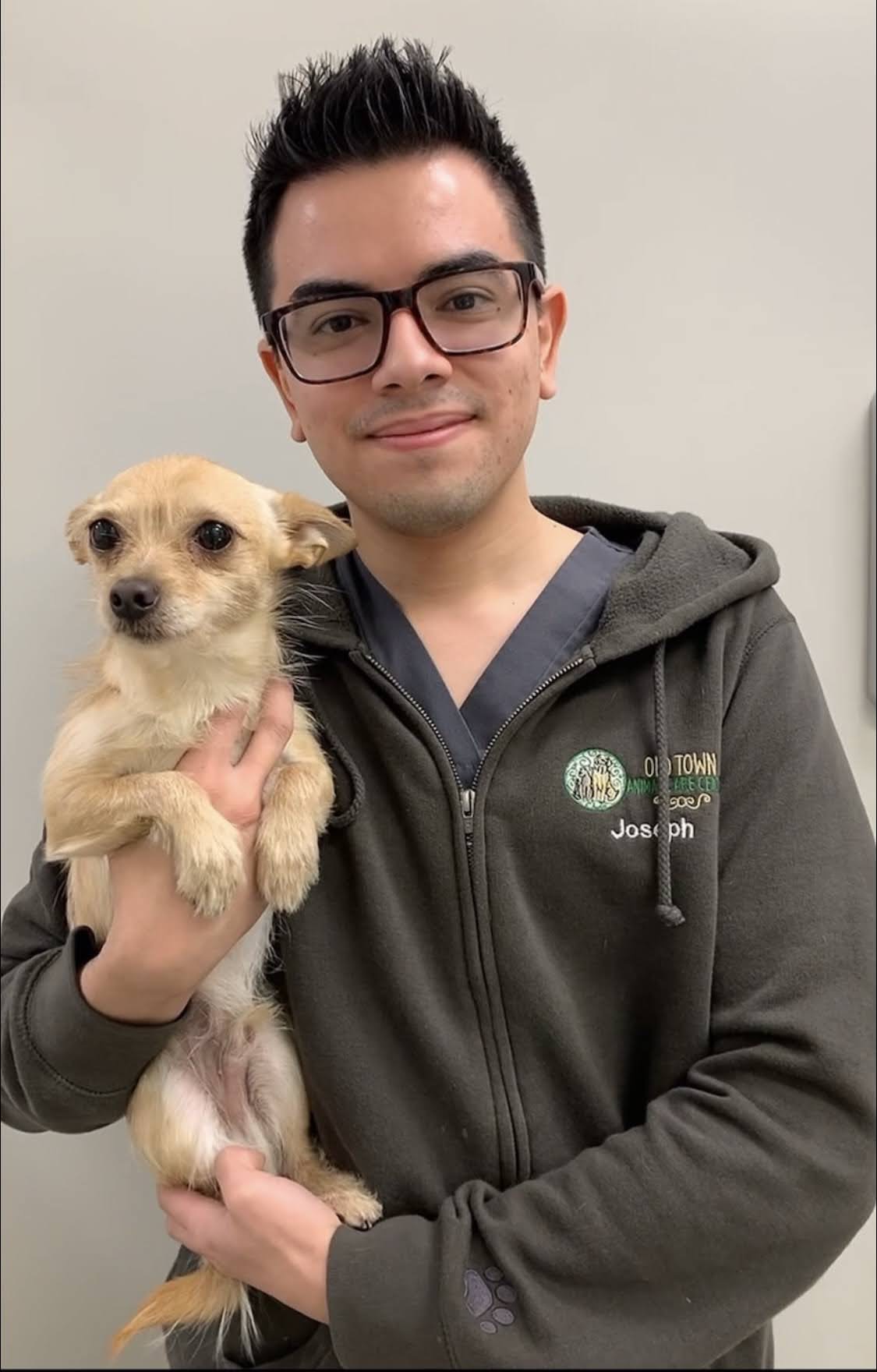 Joseph smiling holding a dog