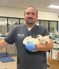 Dr Schaefer smiling and holding a puppy