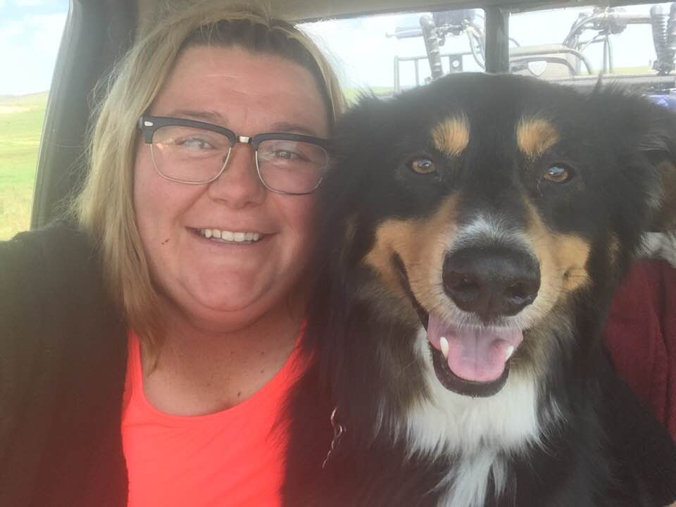 Laramie Smovir smiling with a smiling dog